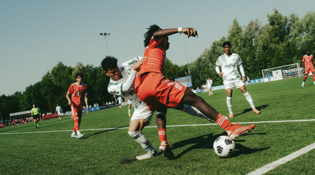 Football players in red and white jerseys competing for ball control during match with dribbling and defensive pressure