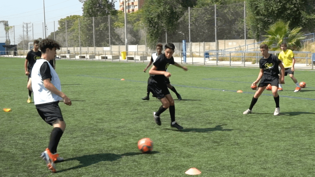 U-12 U-14 youth players performing 4v2 rondo drill on Toronto football pitch developing basic football skills and teamwork