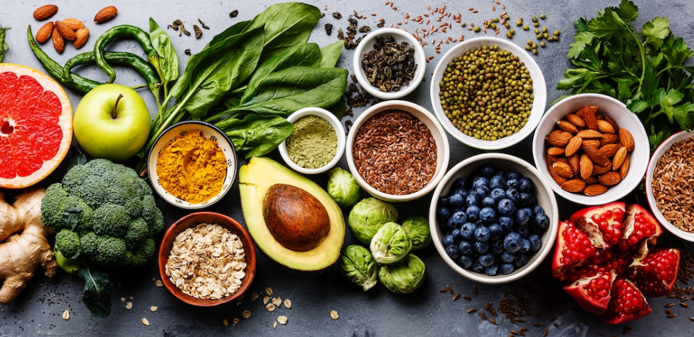 Colorful display of fresh superfoods including vegetables, fruits, nuts, seeds and healthy ingredients for football nutrition